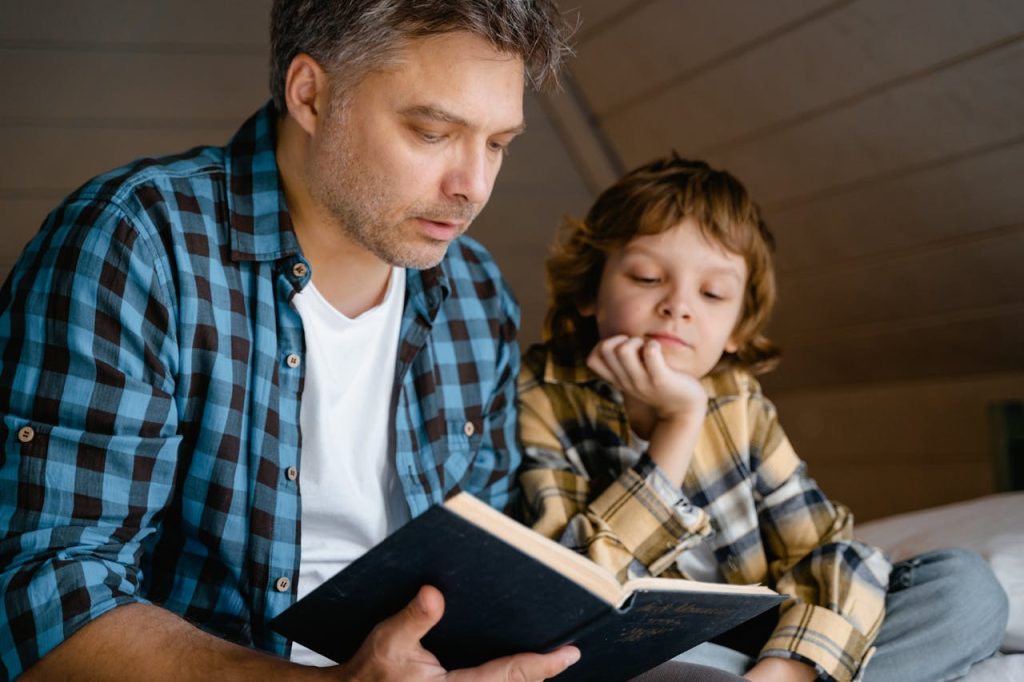A father and son sharing a tender moment reading a bedtime story together.